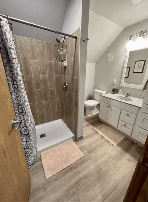 Bathroom with tub, shower curtain and white vanity