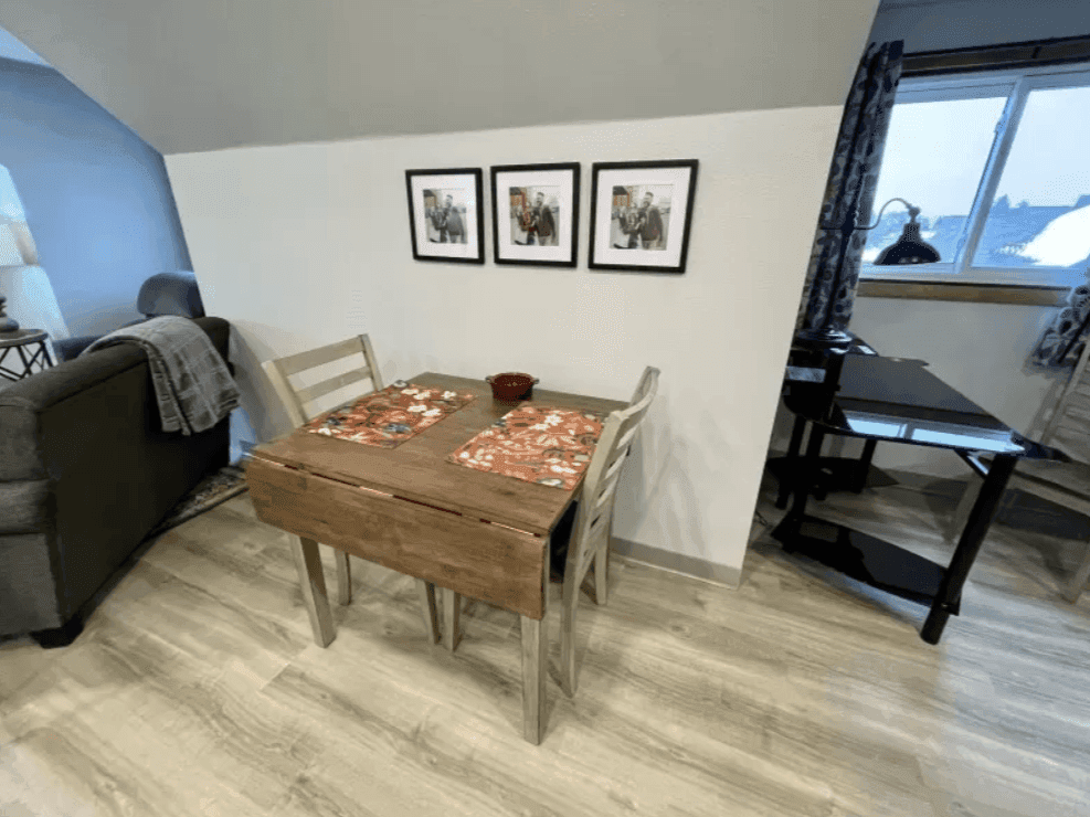 Dining table beside an armchair and window