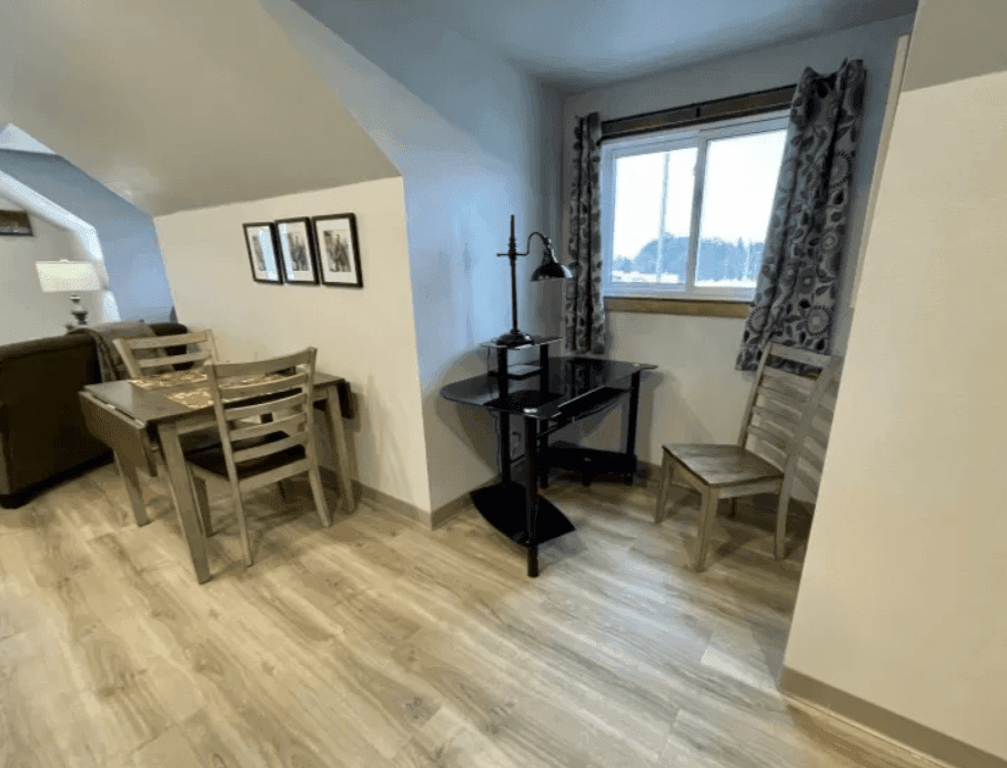 Dining area and window beneath the apartment's sloped ceiling