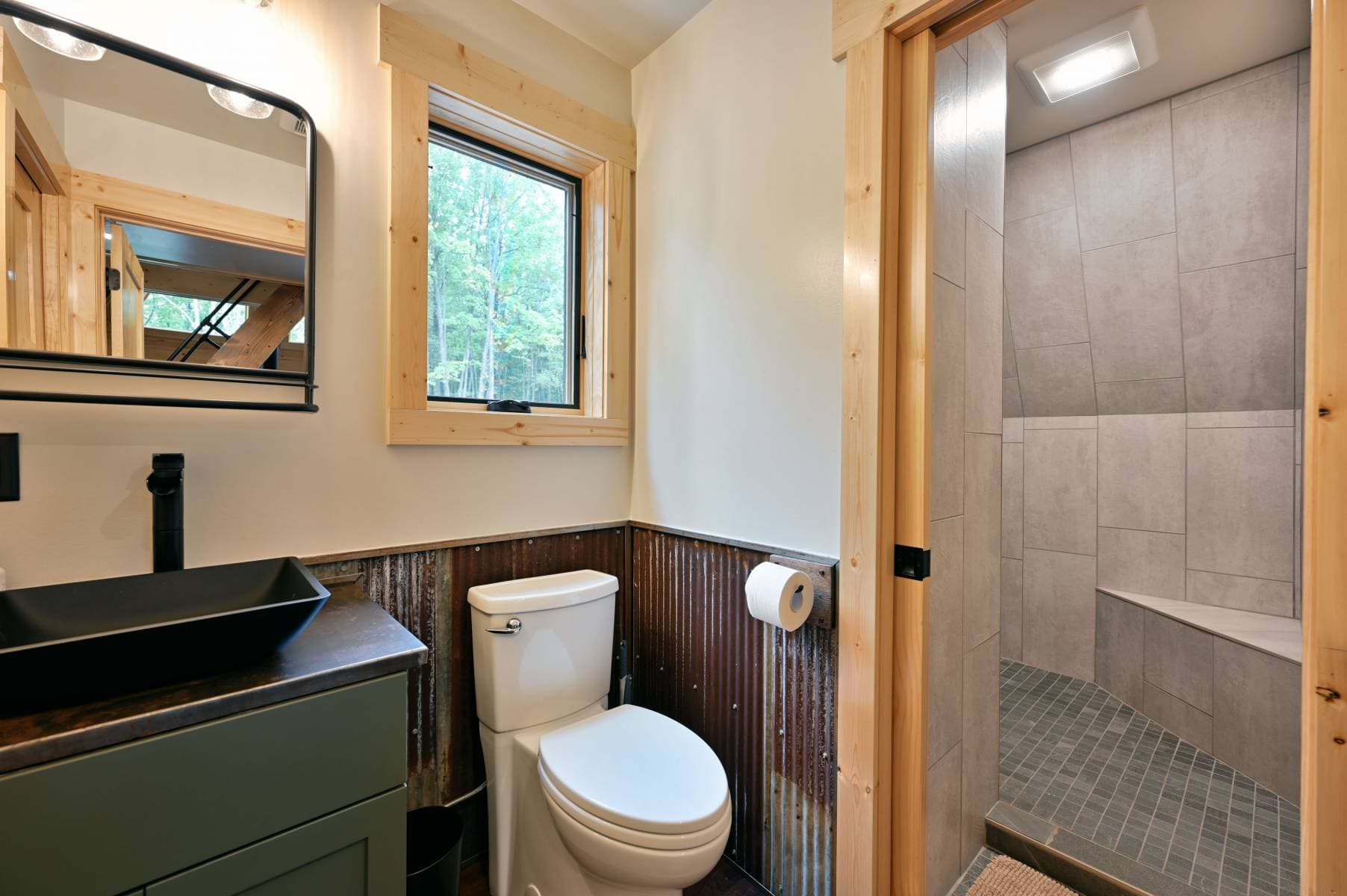 Bathroom with green vanity, toilet and tiled shower