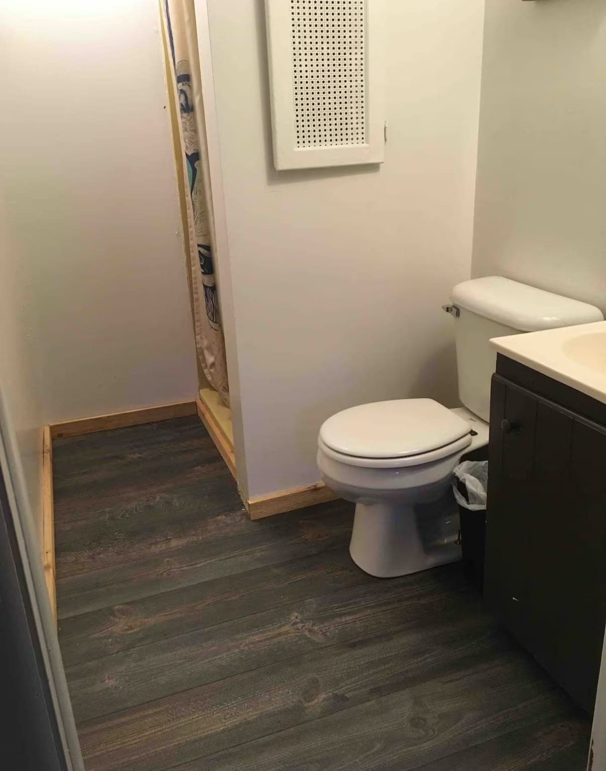 Bathroom with toilet, vanity edge and gray flooring