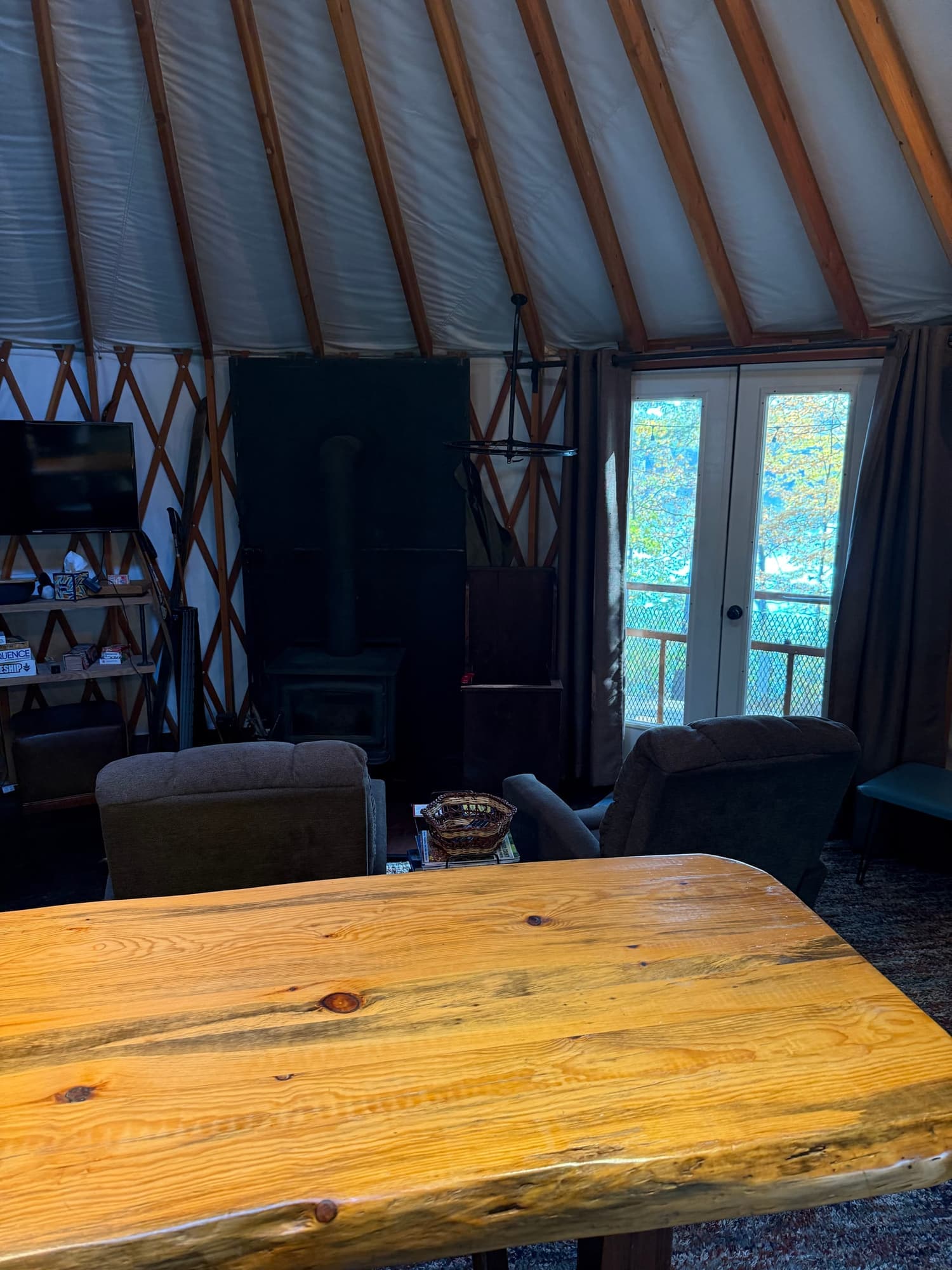 Wooden table inside the yurt facing the glass entrance doors
