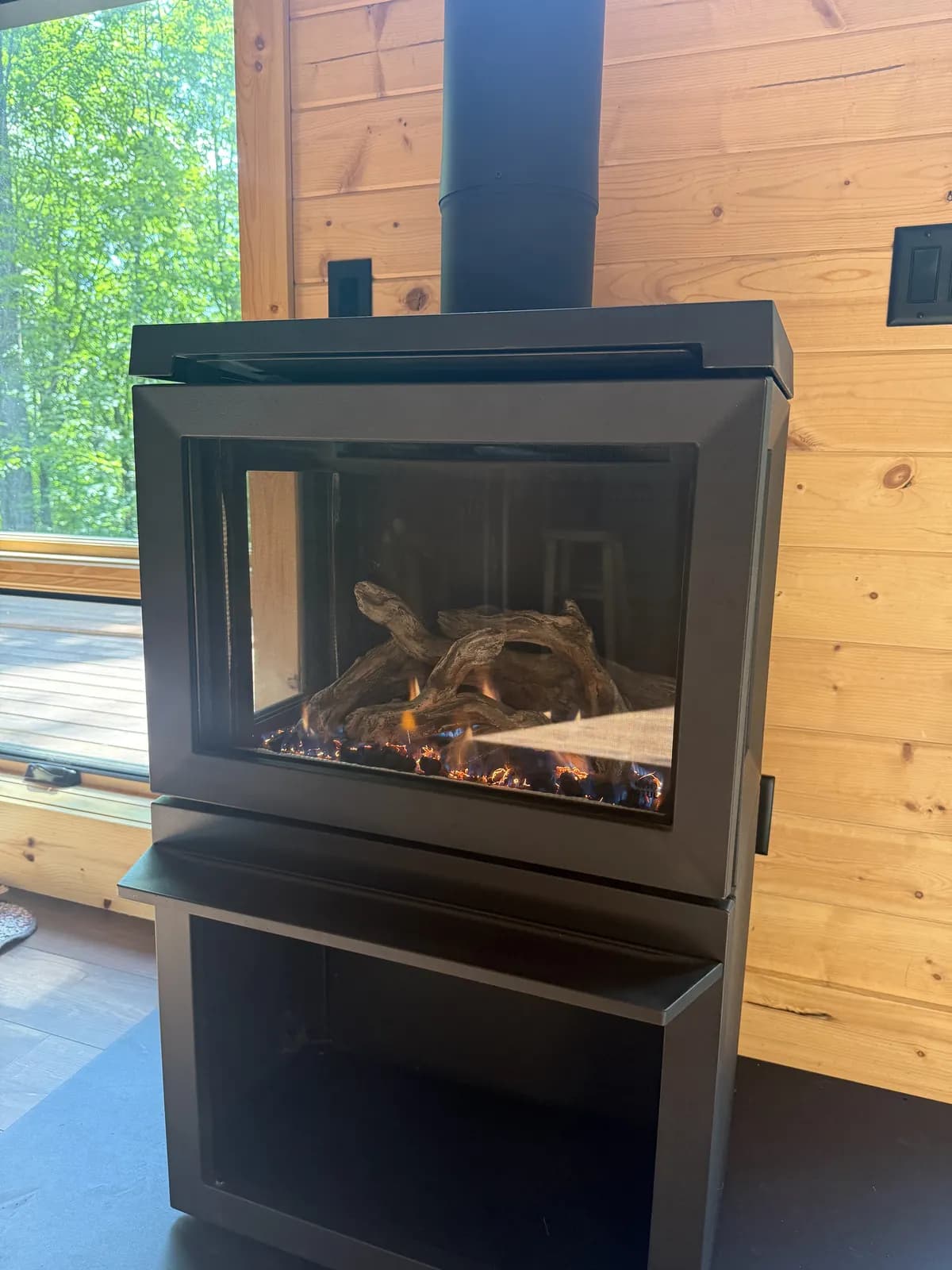 Close-up of flames behind the glass door of the cabin's black fireplace