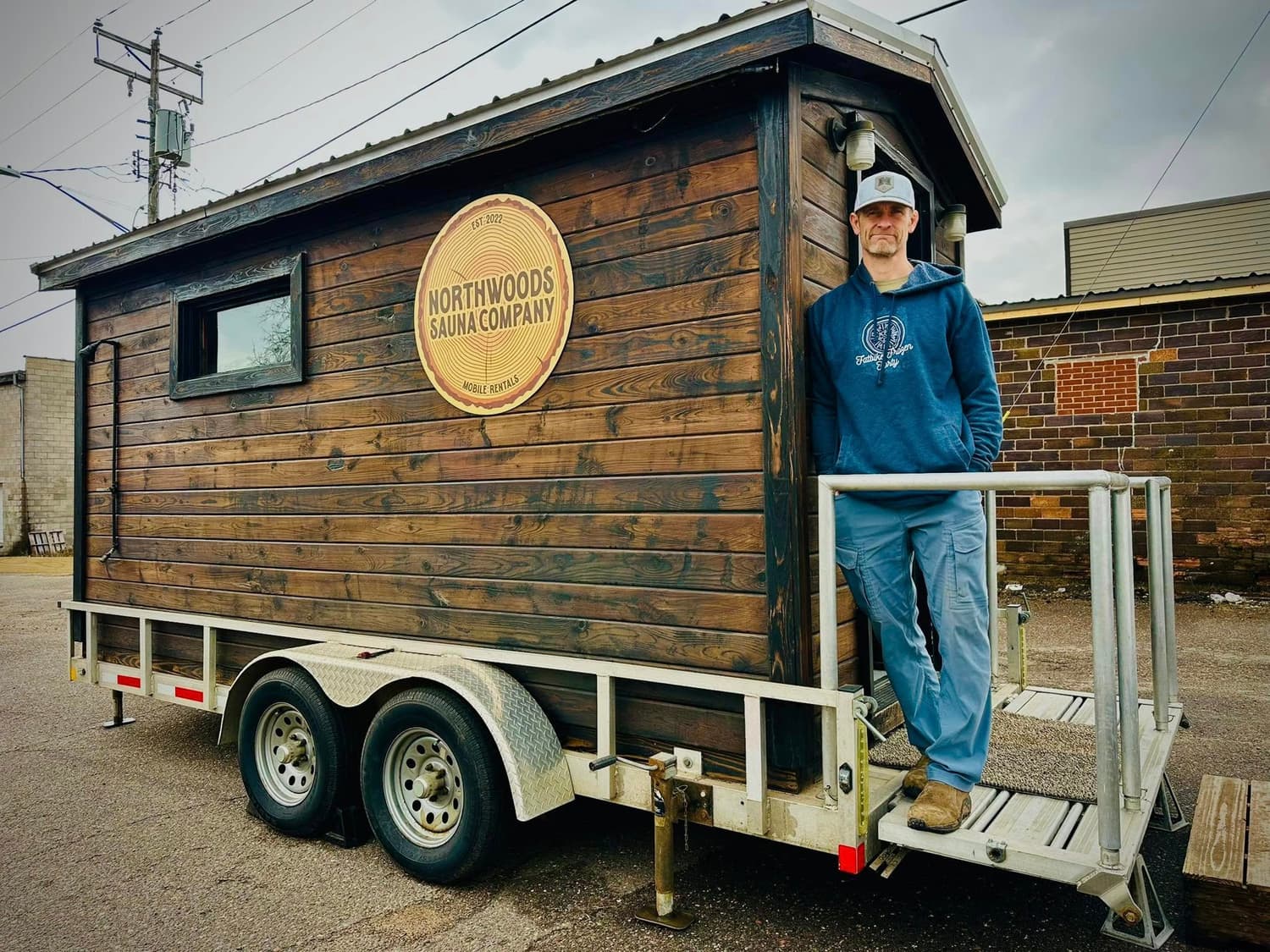 Ben Welnak, owner of Northwoods Sauna Company, standing next to one of our mobile saunas